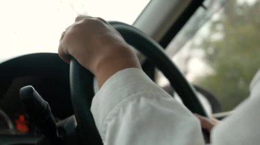 Araba süren genç bir kadın, elini siyah direksiyona koydu ve dikkatli bir şekilde ileriye doğru gitti..