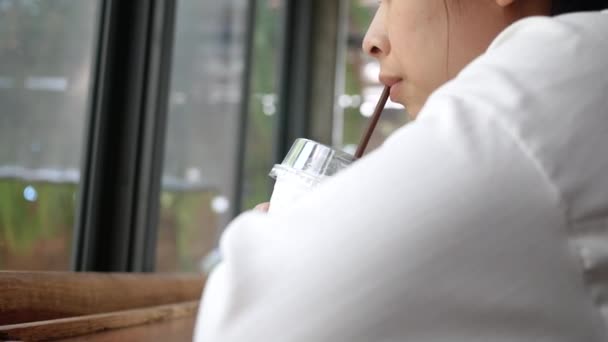 Attraktive Frau Sitzt Fenster Und Schaut Weg Während Sie Eiskaffee — Stockvideo