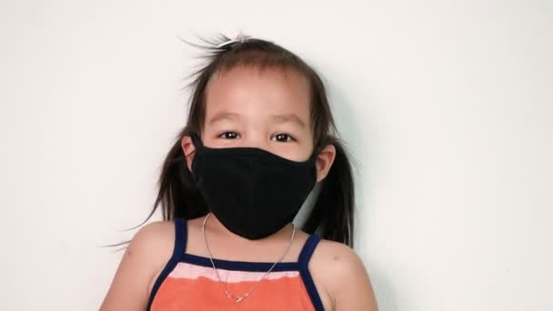 快乐的亚洲小女孩 戴着面部面具 以防止空气污染或白色背景的病毒传播 保健概念 — 图库视频影像