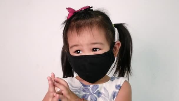白い背景に大気汚染やウイルスの流行から保護するための顔のマスクを身に着けている幸せなアジアの子供の女の子 ヘルスケアの概念 — ストック動画