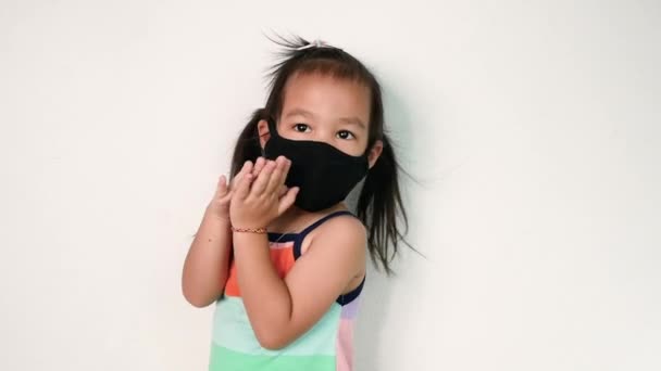 白い背景に大気汚染やウイルスの流行から保護するための顔のマスクを身に着けている幸せなアジアの子供の女の子 ヘルスケアの概念 — ストック動画