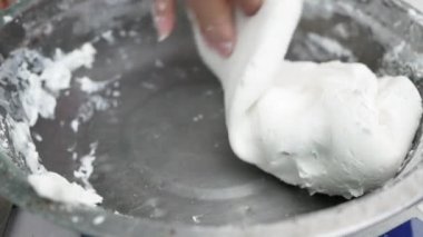 Asyalı genç bir kadın Tayland usulü tatlı ya da Şamandıra tatlısı yapıyor. Unu hindistan cevizi sütüyle karıştırma ve mangırı yoğurup şamandıra köftesi yapma sürecine yakın çekim.