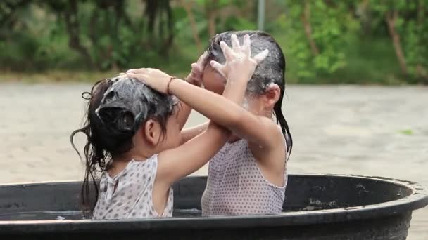 快乐的兄弟姐妹小女孩在院子里的塑料浴缸里洗你的头发 孩子们在炎炎夏日喜欢户外活动 保健概念 — 图库视频影像
