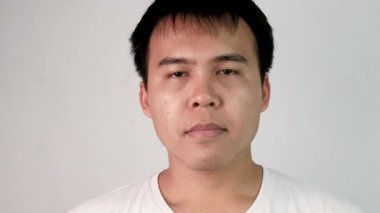 Beyaz arka planda uykulu ve esnemiş bir gencin yakın plan yüzü..