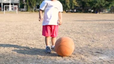 Asyalı bir aile yaz parkında futbol oynarken eğleniyor. Mutlu aile ve çocukluk kavramı.