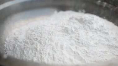 Asyalı genç bir kadın Tayland usulü tatlı ya da Şamandıra tatlısı yapıyor. Unu hindistan cevizi sütüyle karıştırma ve mangırı yoğurup şamandıra köftesi yapma sürecine yakın çekim.