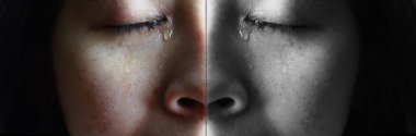 Close-up face of Asian woman crying with tears, isolated on dark background. Concepts of emotion and expression of human. clipart