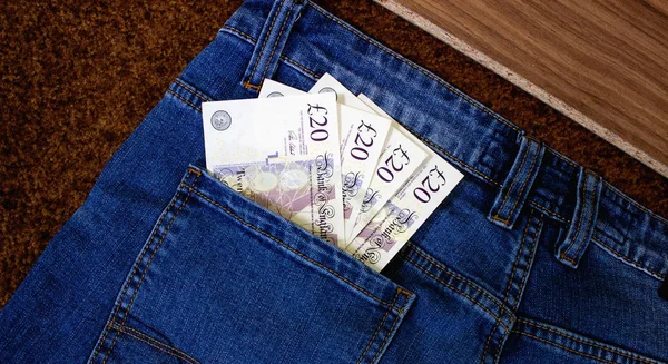 Money in the pocket of jeans. English pounds