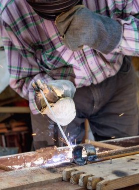 Endüstride çalışmak. Bir adam kaynak makinesiyle çalışır.