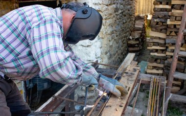 Endüstride çalışmak. Bir adam kaynak makinesiyle çalışır.