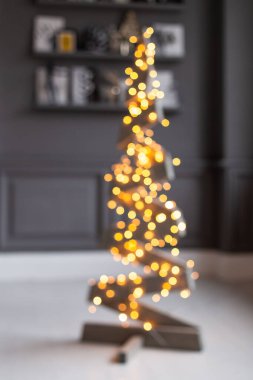 Tahtadan yapılmış ve çelenge sarılmış sıradışı bir köknar ağacının bulanık fotoğrafı..