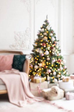 Süslü nükteli çelenk ve beyaz kanepenin yanında duran oyuncak Noel ağacının mavi fotoğrafı..