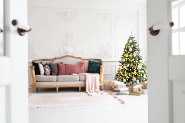 Foto borrosa de sofá blanco junto al árbol de Navidad rodeado de cajas de regalo — Foto de Stock