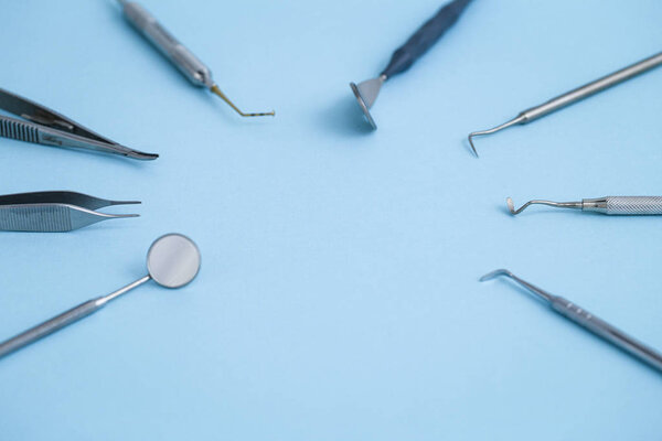 Стоматологическое оборудование, расположенное по кругу на синем фоне
