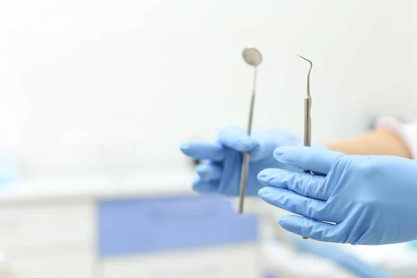 Closeup of dental mirror and dental probe in hands of doctor. Selective focus — Stock Photo, Image