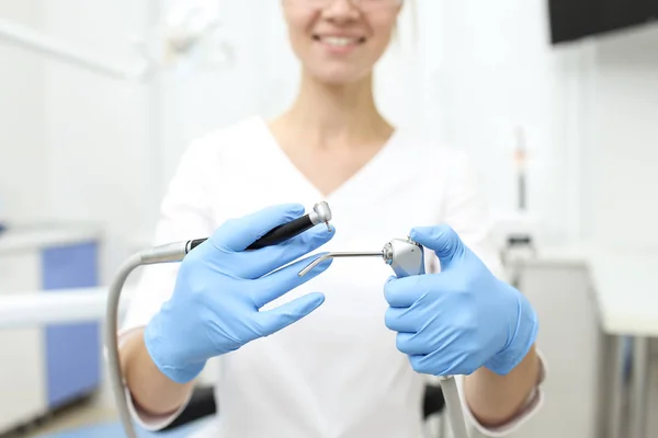 Closeup of dentist tools in hands of womn in blue glowes. Selective focus — Stock Photo, Image
