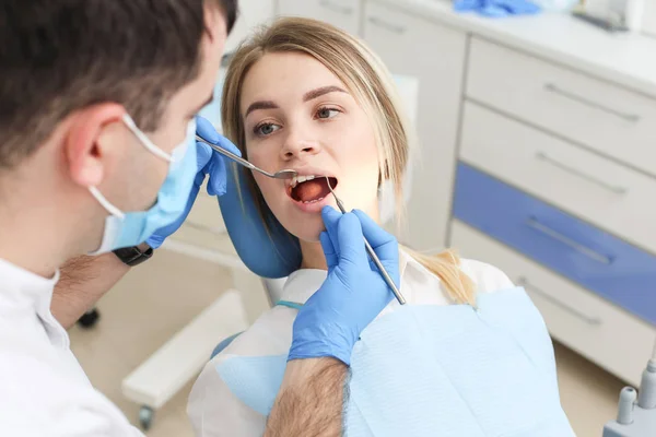 Donna bionda si siede sulla sedia del dentista e si sottopone a controllo dentistico — Foto Stock