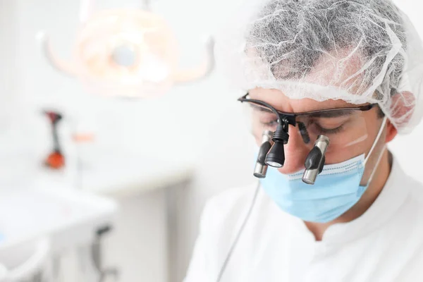 Closeup of male dentist head with mask and glasses put on. Selective focus — Stock Photo, Image