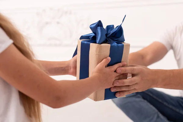 Primer plano de las manos de la niña y su padre que tienen la caja de regalo en las manos. Enfoque selectivo — Foto de Stock