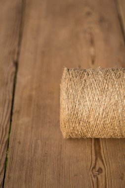 Ahşap arka planda bir sicim rulosu. Seçici odaklanma. Yakın plan. Metin için boş alan.