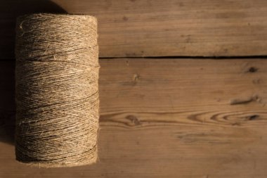 Ahşap arka planda bir sicim rulosu. Seçici odaklanma. Yakın plan. Metin için boş alan.