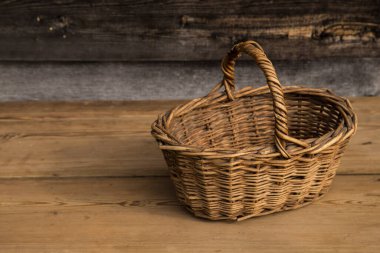 Ahşap bir arka planda antik hasır sepet. Seçici odaklanma. Metin için boş alan.