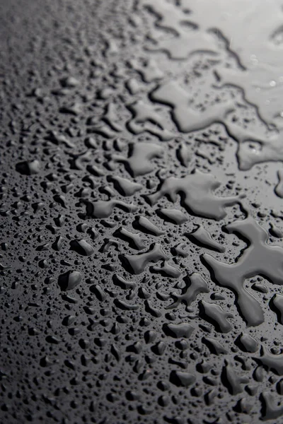 Drops of water on black texture. Selective focus. — Stock Photo, Image