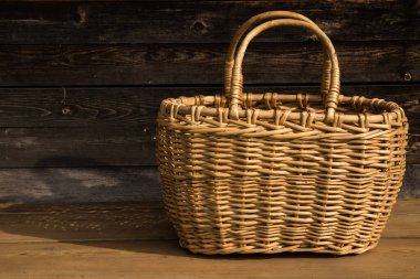 Ahşap bir arka planda antik hasır sepet. Seçici odaklanma. Metin için boş alan.