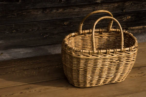 Ancient wicker basket on a wooden background. Selective focus. Free space for text. — Stock Photo, Image