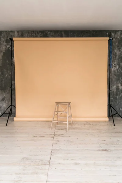 带米色纸背景和椅子的照相馆的工作空间. — 图库照片