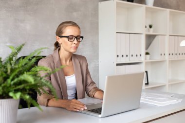 Gözlüklü sarışın kadın Laptop 'la çalışıyor. Ofis çalışanı