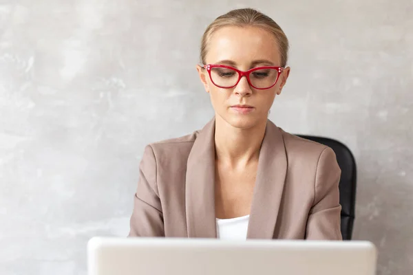 Mulher loira de óculos trabalhando com lapatop. Trabalhador de escritório — Fotografia de Stock