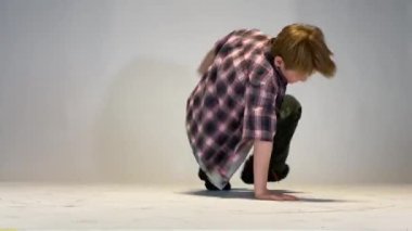 Küçük çocuk breakdance yapıyor.