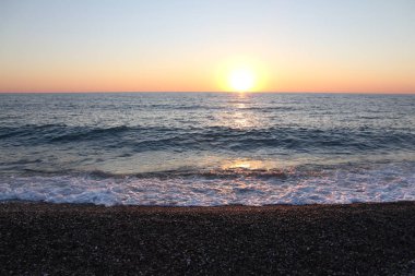 Güneş, Kara Se 'nin yüzeyinin üstündeki ufka yaklaşıyor.