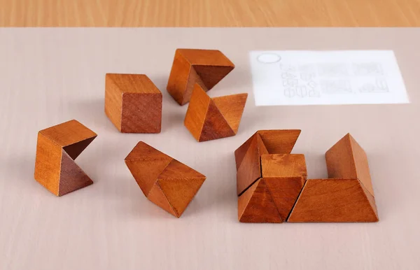 Părți ale unui puzzle din lemn incomplet asamblat sunt pe masă — Fotografie, imagine de stoc