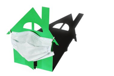 Evin ön kapısı tıbbi bir maske ile korunuyor. Enfeksiyon riski olan kendini izole etme kavramı. Beyaz bir arkaplanda izole edilmiş