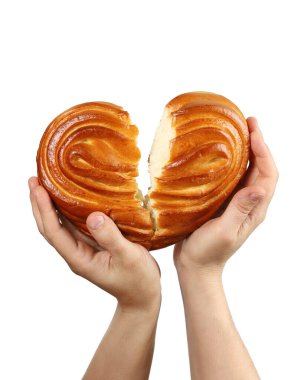 Eller kırık kalp şeklindeki çörekleri destekliyor. Kırık bir aşk ya da hasta bir kalp kavramı. Beyaz arkaplanda izole edilmiş, yakın plan