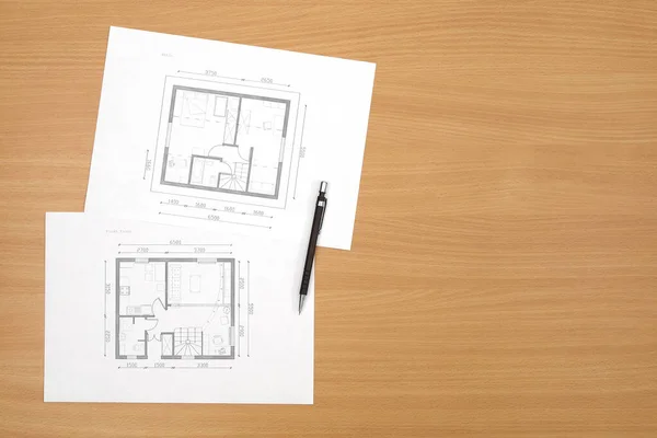 Architecture floor plan on paper is located on a table with a wood texture. Top view with copy space