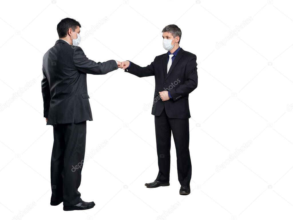 Fist bump greeting. Two people in suits greet each other in a meeting. They give up the traditional handshake. Persons in full growth isolated on a white background