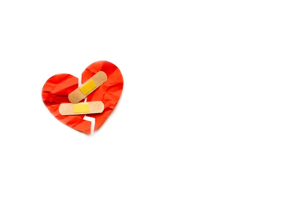 Broken red heart symbol with medical patch on white background, love concept. healing — Stock Photo, Image