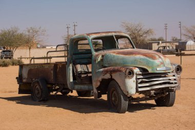 Namibya 'da Solitaire' de bir benzin istasyonunun yakınında terk edilmiş eski paslı hurda bir araba Namib-Naukluft Milli Parkı..