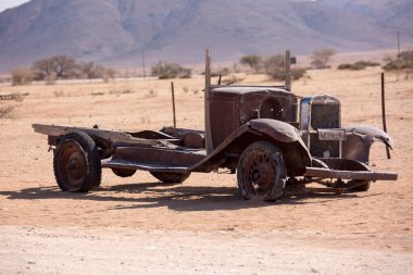 Namibya 'da Solitaire' de bir benzin istasyonunun yakınında terk edilmiş eski paslı hurda bir araba Namib-Naukluft Milli Parkı..