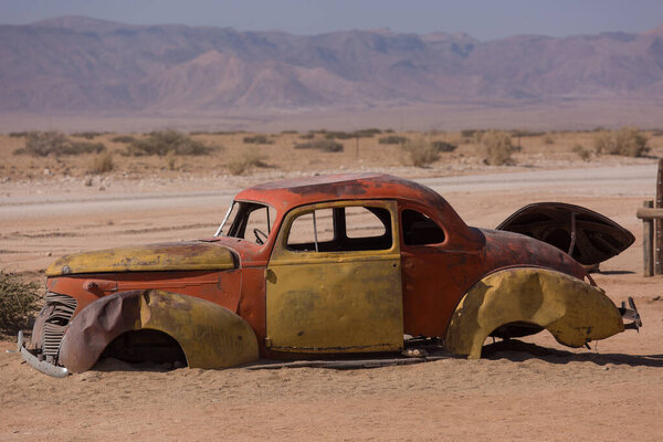 Abandoned old rusty wrecked historic car near a service station at Solitaire in Namibia desert ear the Namib-Naukluft National Park.