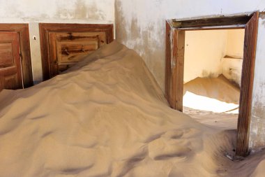 Terk edilmiş ve unutulmuş bina ve oda insanlar tarafından terk edilmiş ve işgal edilen kum fırtınası, Kolmanskop hayalet kasabası, Namib Çölü tarafından ele geçirilmiş.