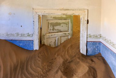 Terk edilmiş ve unutulmuş bina ve oda insanlar tarafından terk edilmiş ve işgal edilen kum fırtınası, Kolmanskop hayalet kasabası, Namib Çölü tarafından ele geçirilmiş.