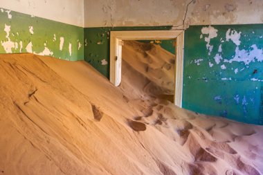 Terk edilmiş ve unutulmuş bina ve oda insanlar tarafından terk edilmiş ve işgal edilen kum fırtınası, Kolmanskop hayalet kasabası, Namib Çölü tarafından ele geçirilmiş.