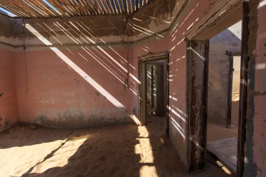 Abandoned and forgotten building and room left by people and being taken over by encroaching sandstorm, Kolmanskop ghost town, Namib Desert clipart