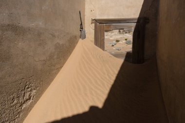 Terk edilmiş ve unutulmuş bina ve oda insanlar tarafından terk edilmiş ve işgal edilen kum fırtınası, Kolmanskop hayalet kasabası, Namib Çölü tarafından ele geçirilmiş.