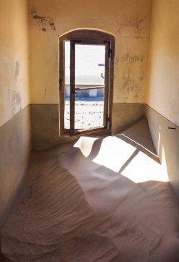 Terk edilmiş ve unutulmuş bina ve oda insanlar tarafından terk edilmiş ve işgal edilen kum fırtınası, Kolmanskop hayalet kasabası, Namib Çölü tarafından ele geçirilmiş.