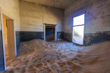 Terk edilmiş ve unutulmuş bina ve oda insanlar tarafından terk edilmiş ve işgal edilen kum fırtınası, Kolmanskop hayalet kasabası, Namib Çölü tarafından ele geçirilmiş.